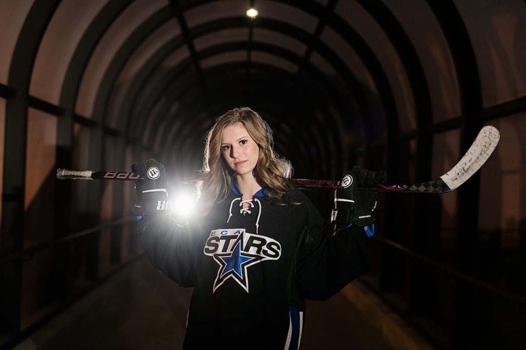 girl in a hockey uniform for the ECA Stars for her Eau Claire senior photos