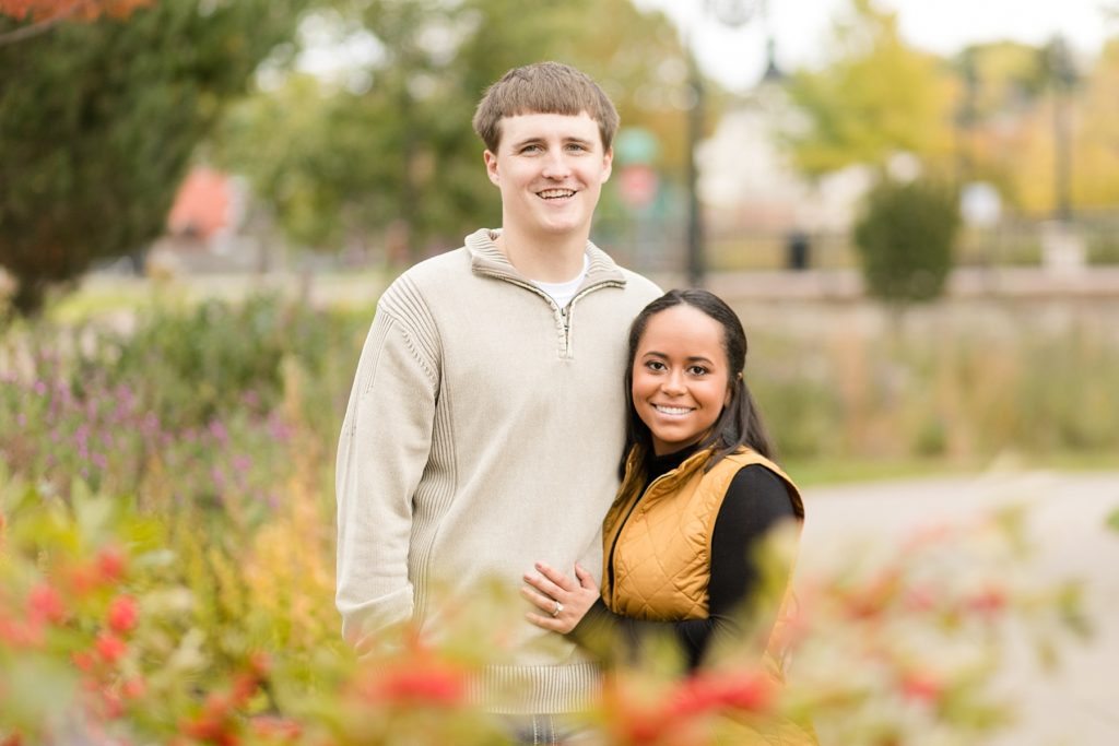 couple in the flowers at Phoenix Park in Eau Claire for their engagement photos
