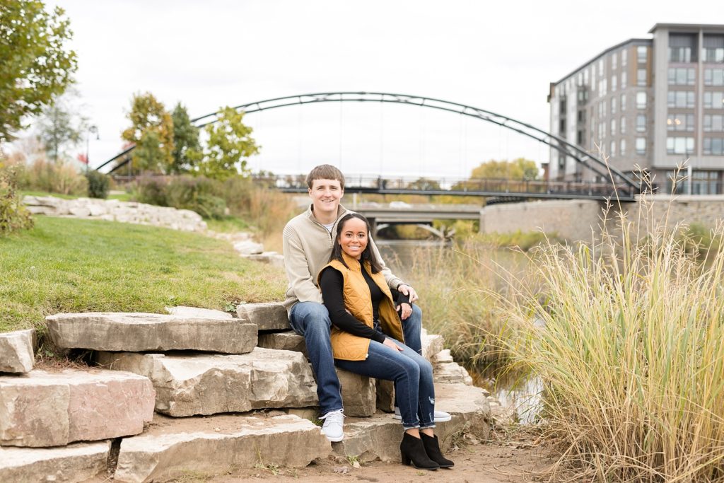 couple with the Eau Claire skyline and new bridge at Phoenix Park behind them in Eau Claire for their engagement photos