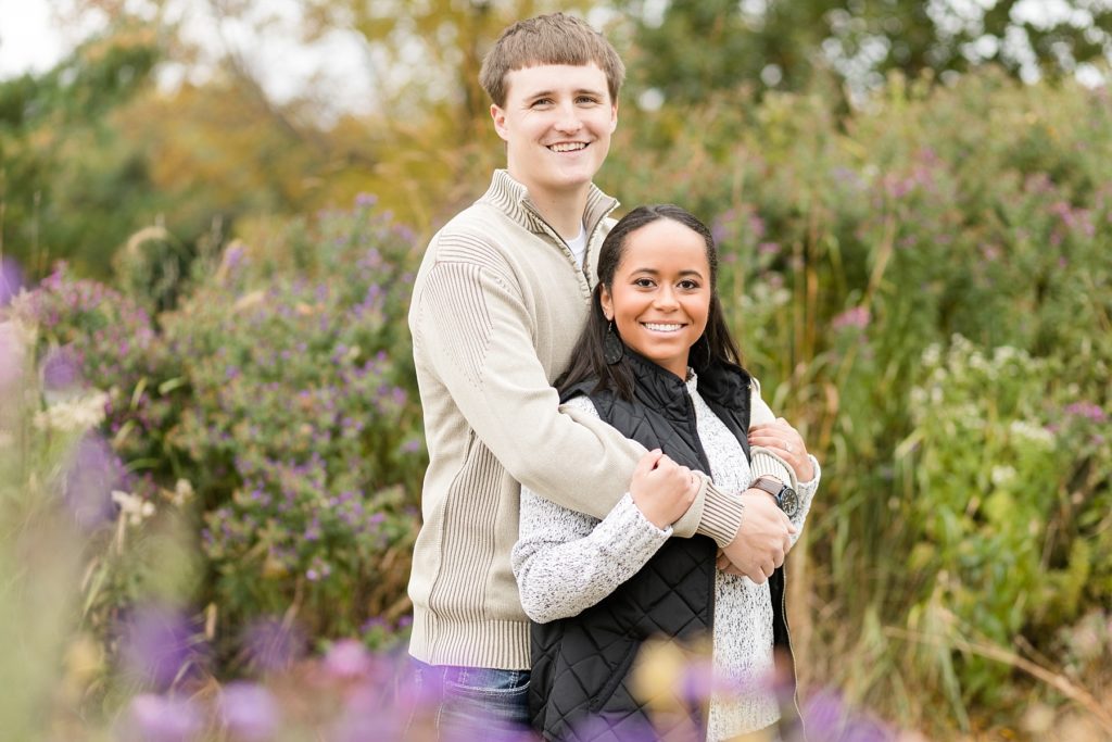 couple in purple flowers during the fall at Phoenix Park in Eau Claire for their engagement photos