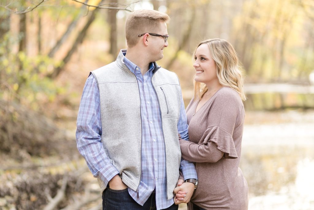 couple smiling at each other for their late fall Irvine Park engagement photos in Chippewa Falls