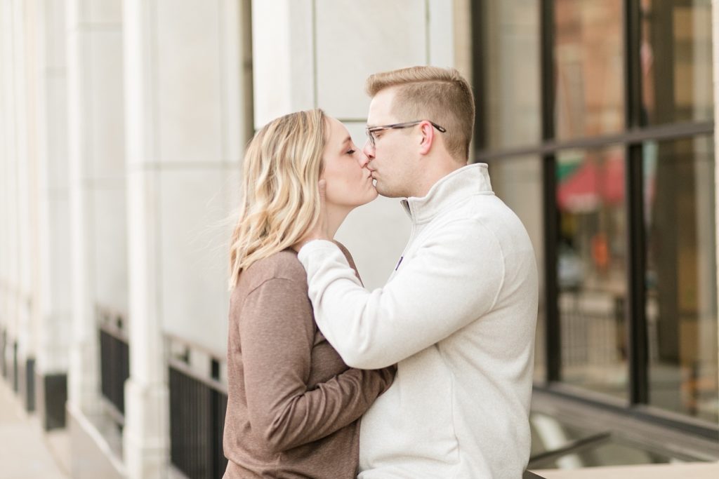 couple kissing in a color photo in downtown Chippewa Falls for their engagement photos