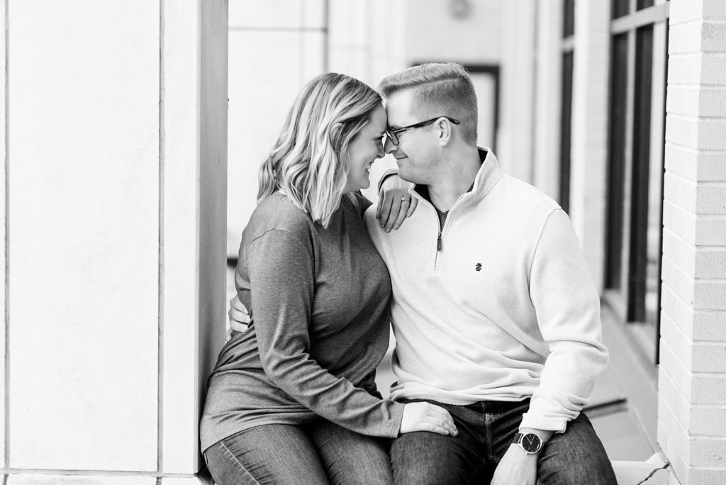 couple in a black and white photo with their foreheads together in downtown Chippewa Falls for their engagement pictures