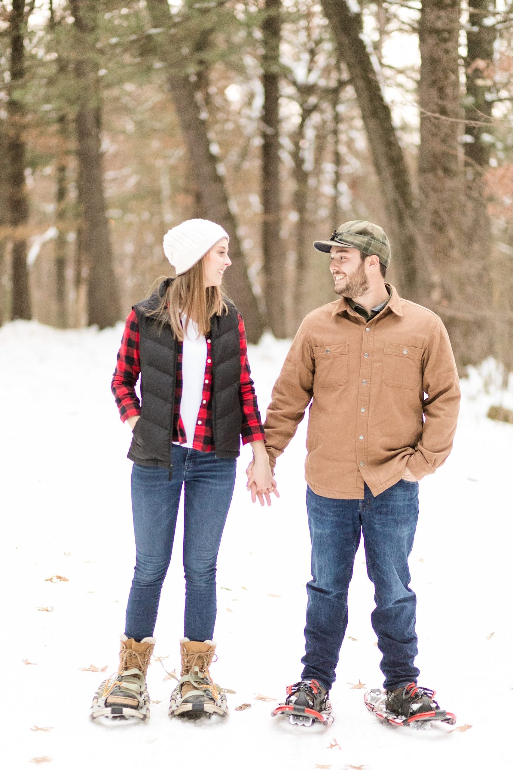 couple snowshoeing for their Wisconsin engagement photos