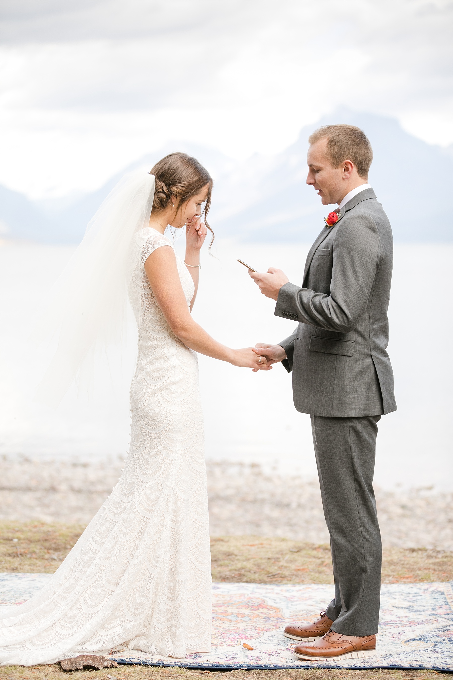 couple reading vows infront of Lake McDonald in Glacier National Park elopement