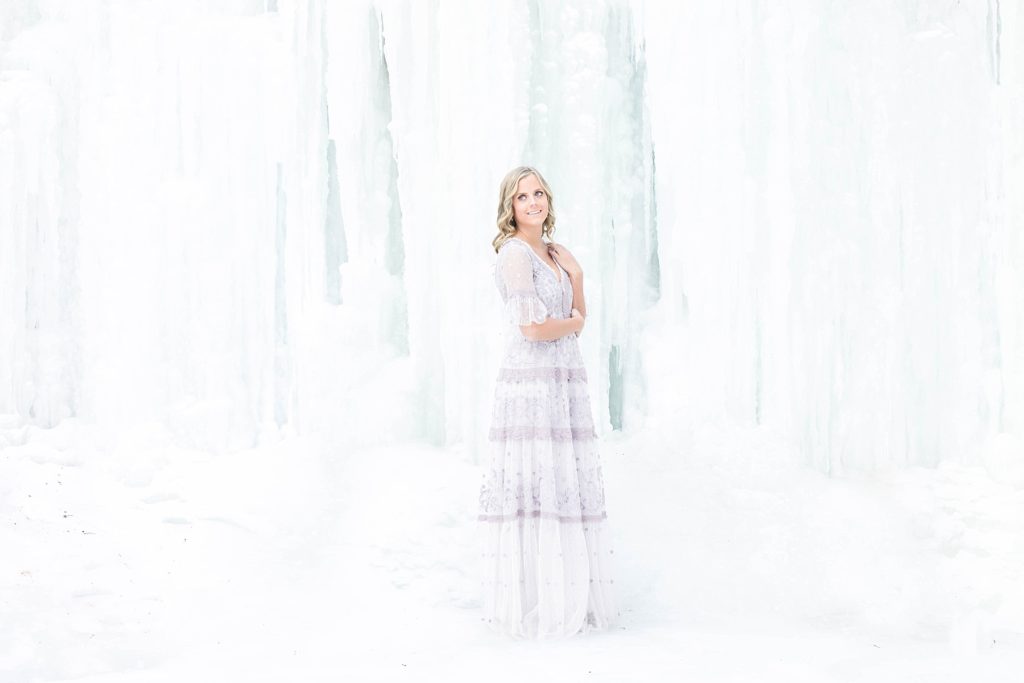 girl in Thread & Needle dress posing infront of an ice formation in Wisconsin for the Sisterhood of the Traveling Dress shoots.