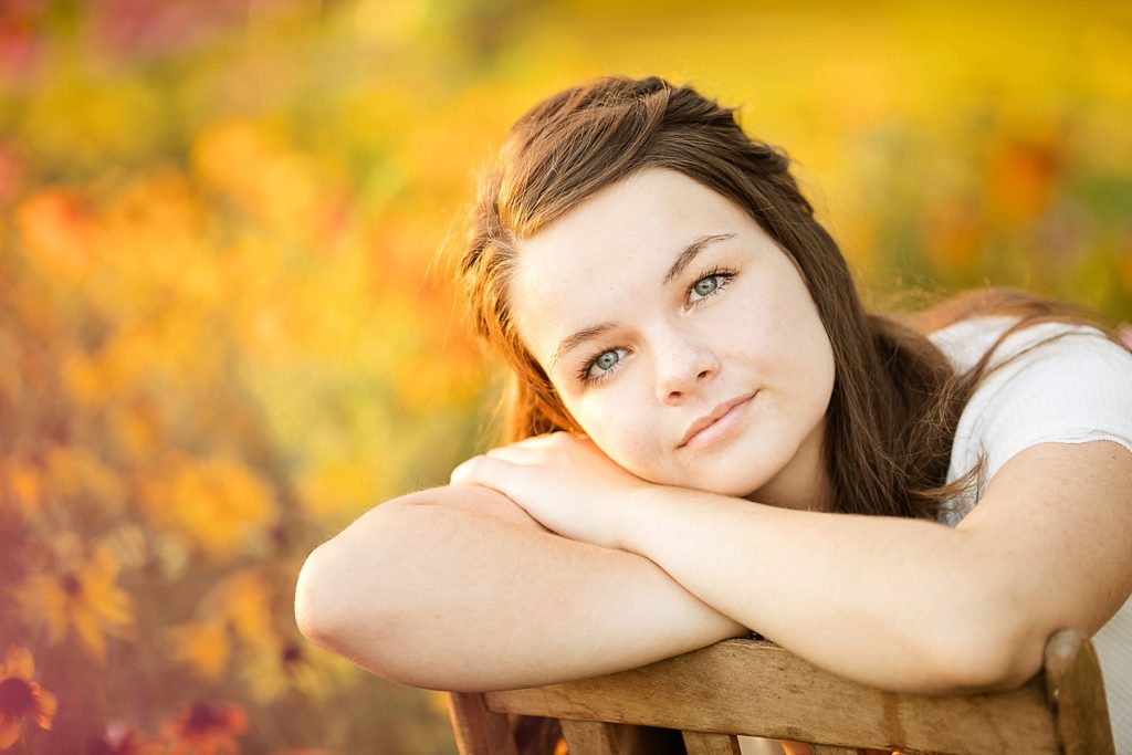 girl leaning on a chair  for her boho senior session in Eau Claire, WI