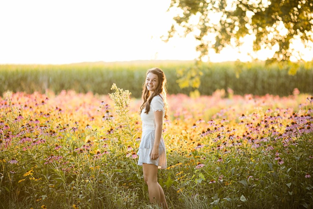 girl in a field of wildflowers for her boho senior session in Eau Claire, WI