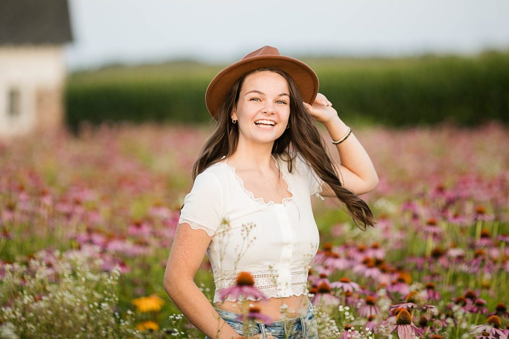 spinning in a field of wildflowers for her boho senior session in Eau Claire, WI