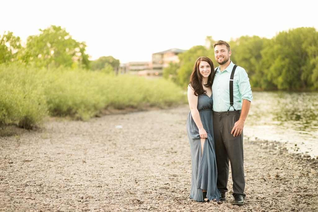 couple on the shore of the river in downtown Eau Claire for their engagement photos