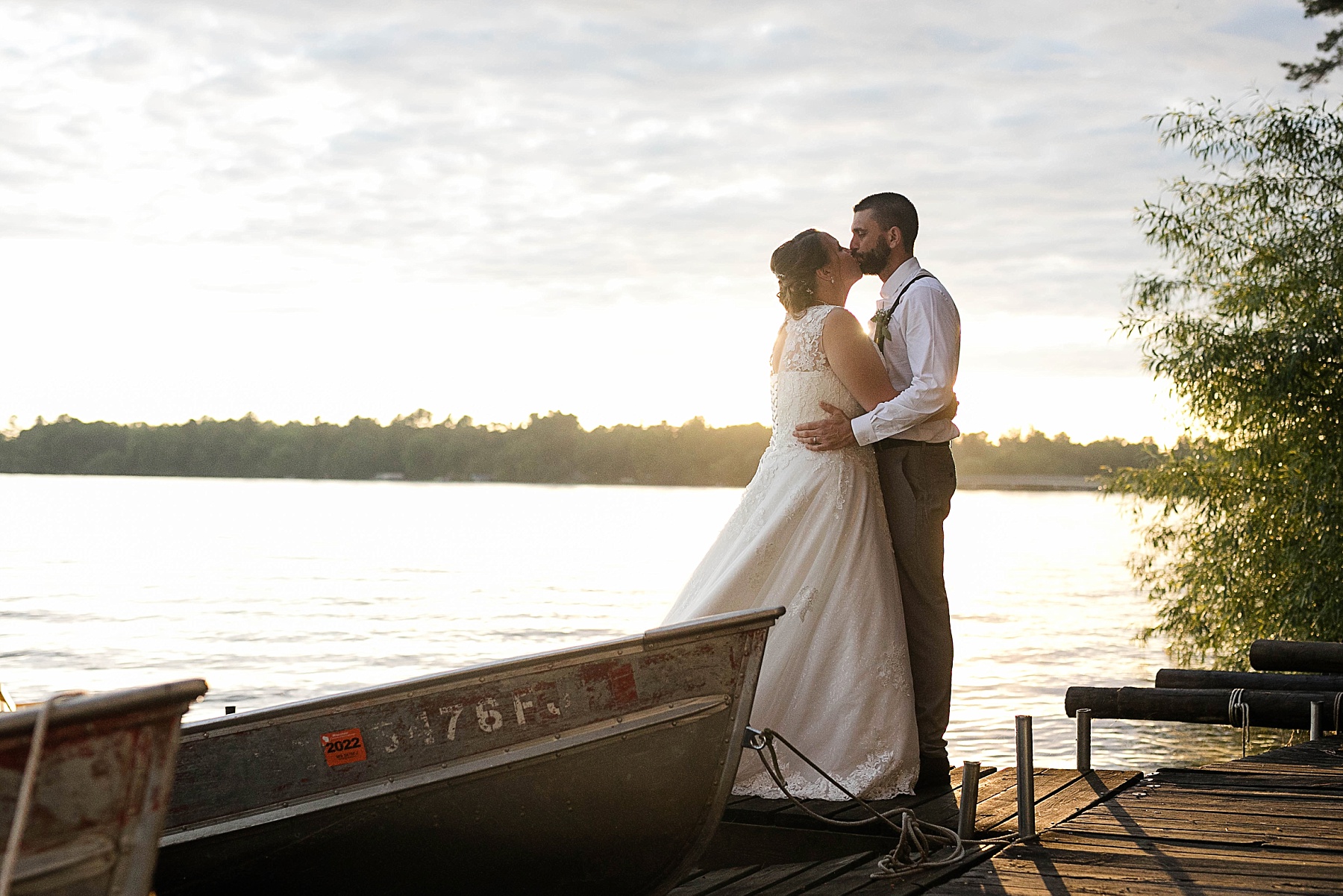 couple kissing on a dock on Lake Chetek at sunset on their wedding day