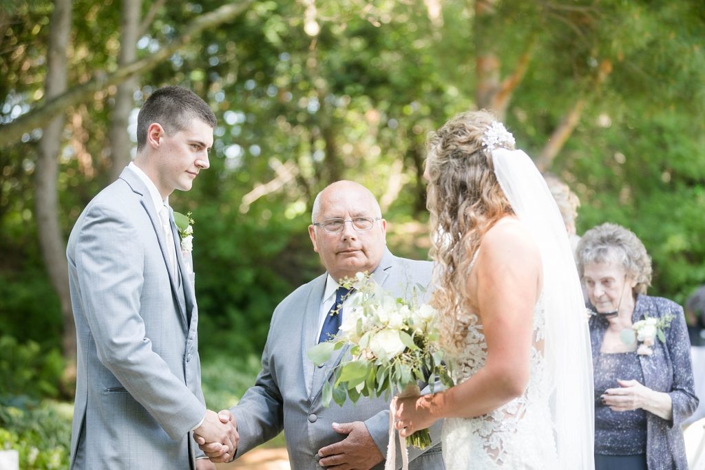 grandfather handing off the bride to the groom at the Florian Gardens in a garden ceremony