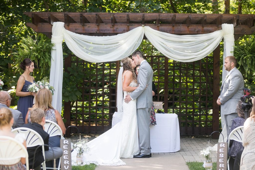 couple kissing during their ceremony in the gardens in Eau Claire WI at The Florian Gardens