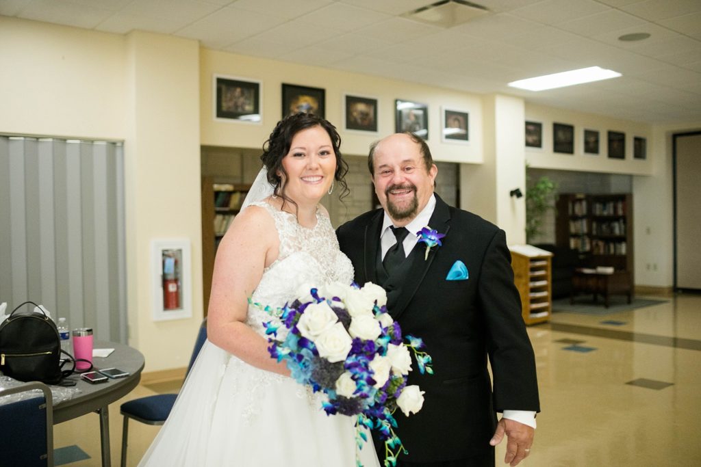bride and her father smiling for the camera before walking her down the aisle at Immaculate Conception Church in Eau Claire