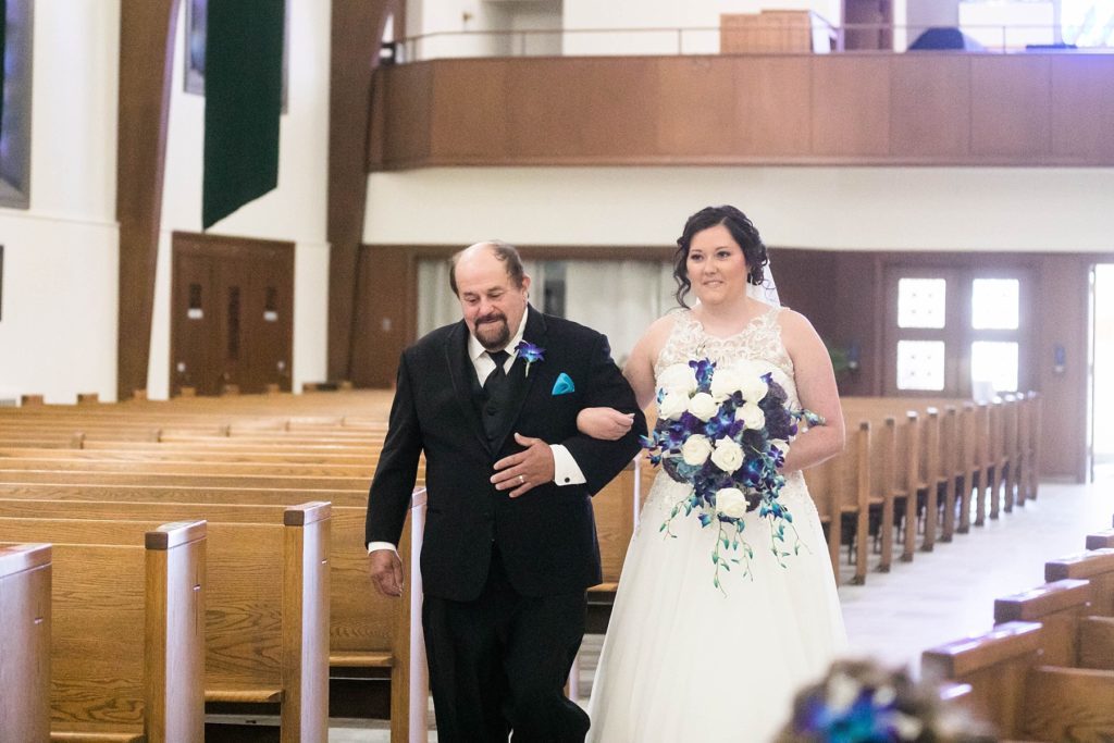 father walking daughter down the aisle at a small wedding at Immaculate Conception Church in Eau Claire