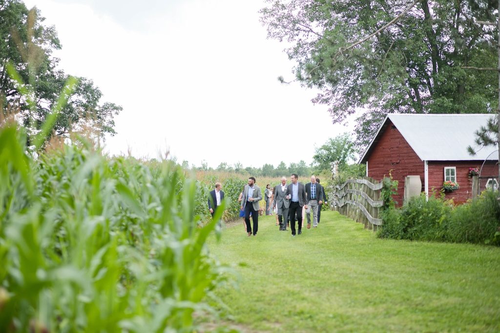 guests walking to the hidden wedding ceremony site at a boho wedding in Wisconsin