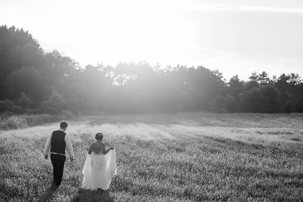 groom holding bride in a field in a black and white photo at Lilydale in Chippewa Falls, WI