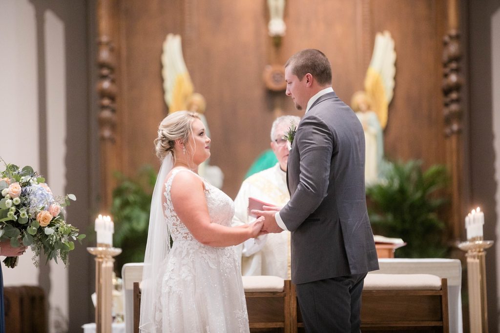 couple share their wedding vows and wedding rites at St. Charles of Borromeo in Chippewa Falls for their wedding