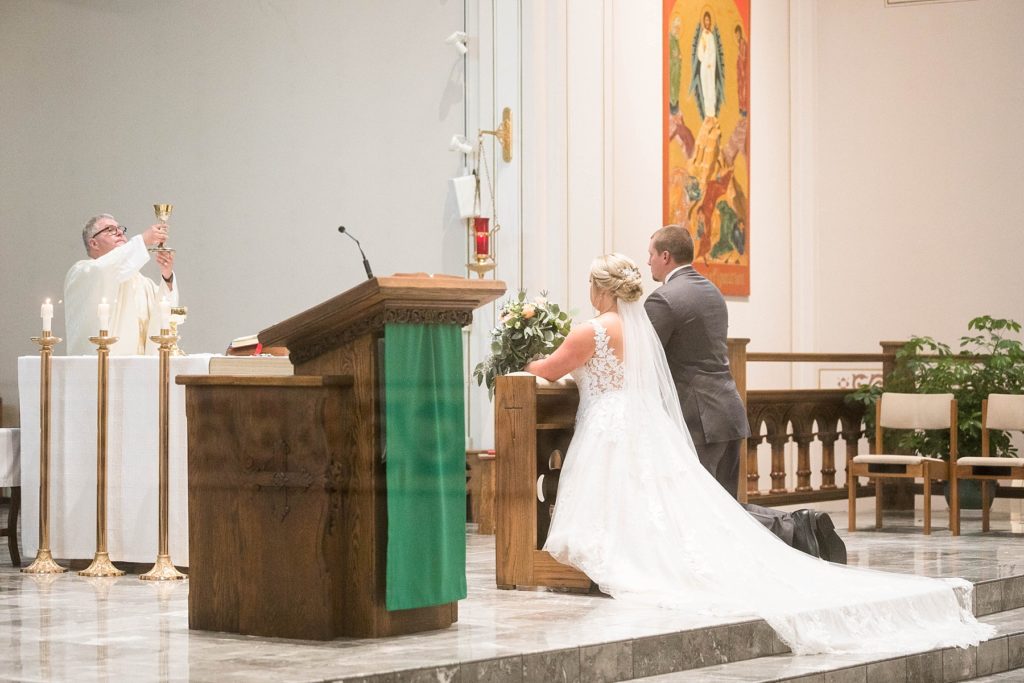 couple during communion at St. Charles of Borromeo in Chippewa Falls for their wedding
