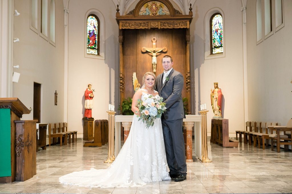 couple smiling in their formal portrait at St. Charles of Borromeo in Chippewa Falls for their wedding