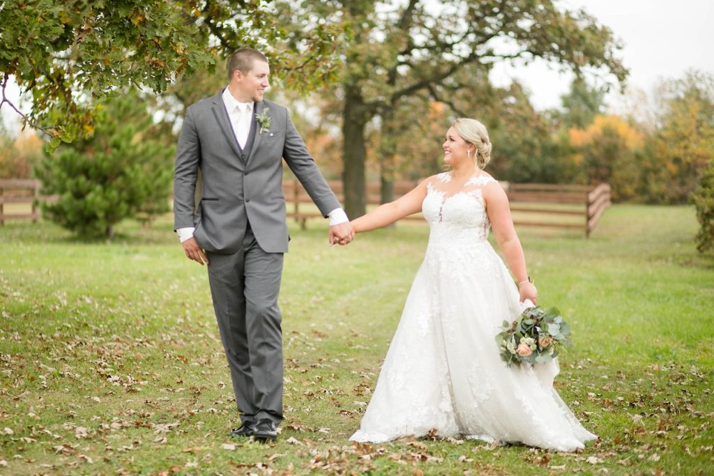 couple look at each other while walking to their reception at their fall wedding at Lilydale in Chippewa Falls