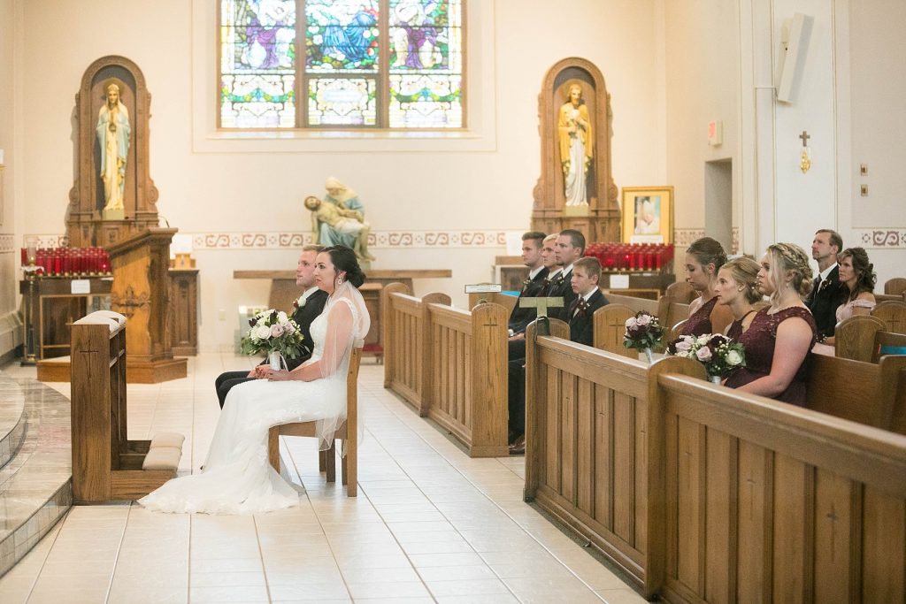bride and groom and their guests during wedding ceremony at St. Charles Borromeo Catholic Church in Chippewa Falls
