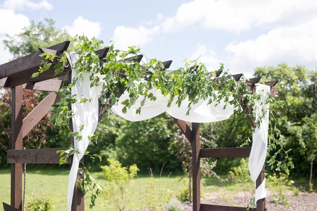 outdoor ceremony space with greenery on pergola at Lilydale Dance Hall & Event Venue in Chippewa Falls