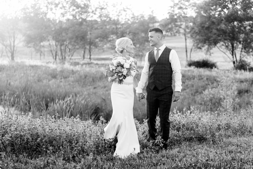 bride and groom laughing and walking in a black and white photo at Lilydale Dance Hall & Event Venue in Chippewa Falls