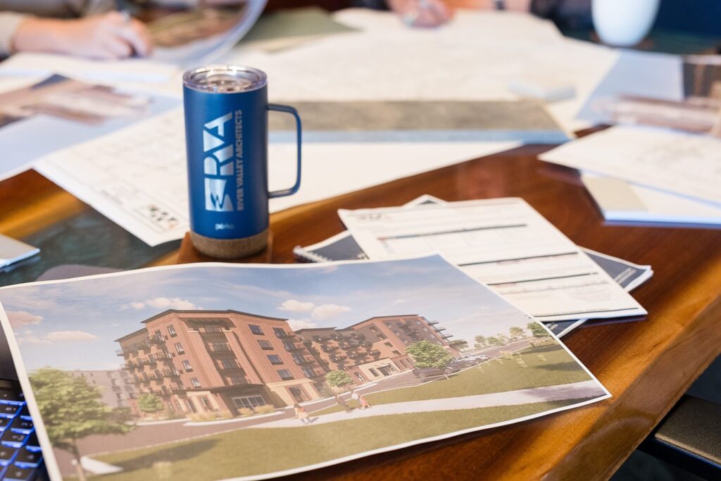 river valley architects rendering set out on a table with a mug with their logo on it